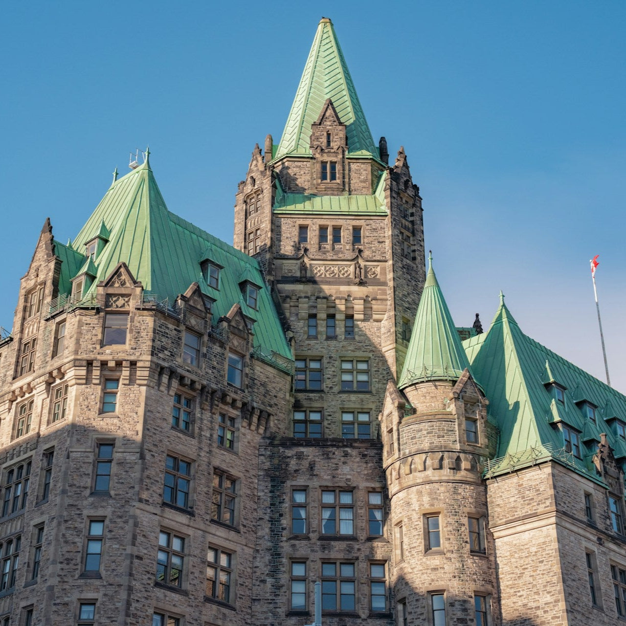 Historic building with green rooftops against a clear blue sky